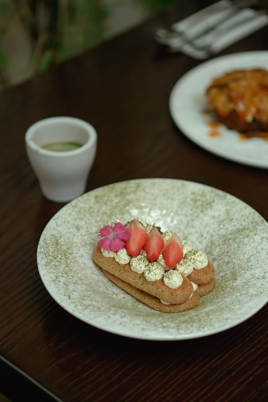 Matcha-missu: ladyfingers piped with mascarpone cream, topped with strawberries and an edible flower